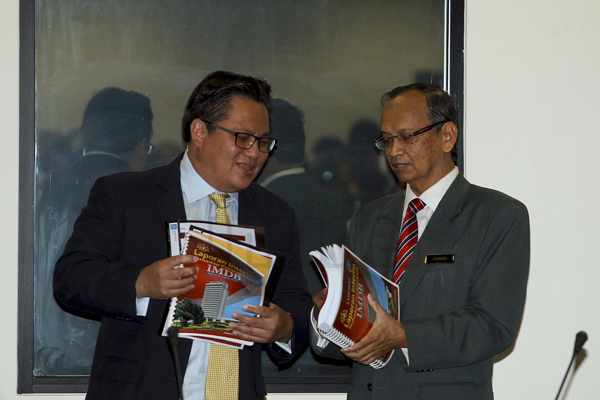 Auditor-General Tan Sri Ambrin Buang handing over the 1MDB report to Public Accounts Committee chairman Datuk Nur Jazlan Mohamed today. The preliminary report will not be made public. – The Malaysian Insider pic by Seth Akmal, July 9, 2015.