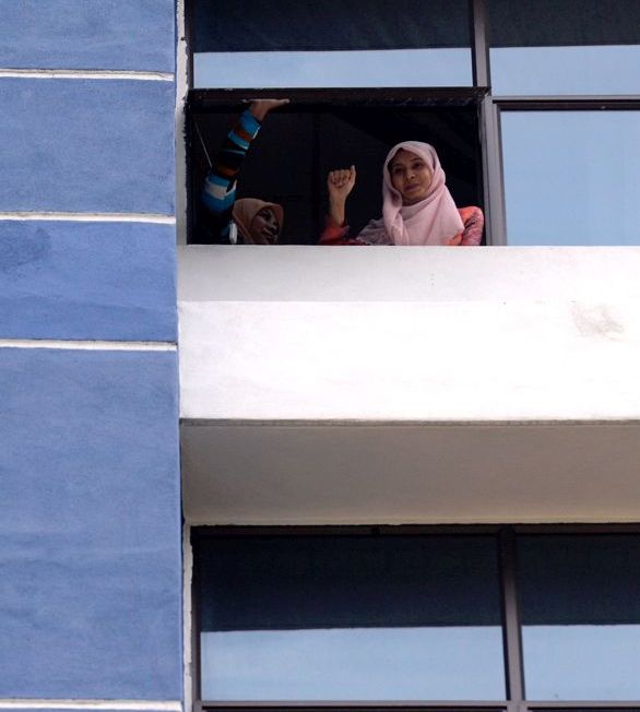 Nurul Izzah clenching her fist as she responds to her supporters from inside the Dang Wangi police headquarters today. She was arrested after going to give her statement pertaining to the #KitaLawan rally on March 7. –  The Malaysian Insider pic by Najjua Zulkefli, March 16, 2015.