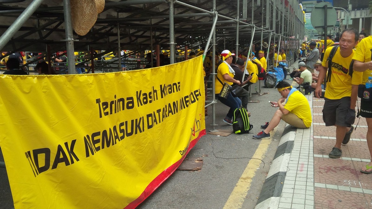 Rally-goers seek shelter under the bleachers set up for Merdeka celebrations tomorrow. – The Malaysian Insider pic, August 30, 2015.