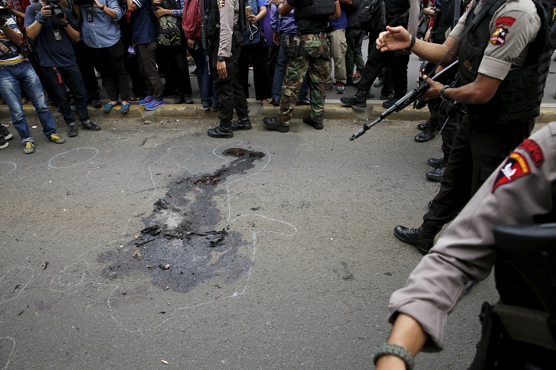 Indonesian police officers with weapons walk near bloodstains at Thamrin business district in Jakarta. Isis has claimed responsibility for the attacks. – Reuters pic, January 14, 2016.