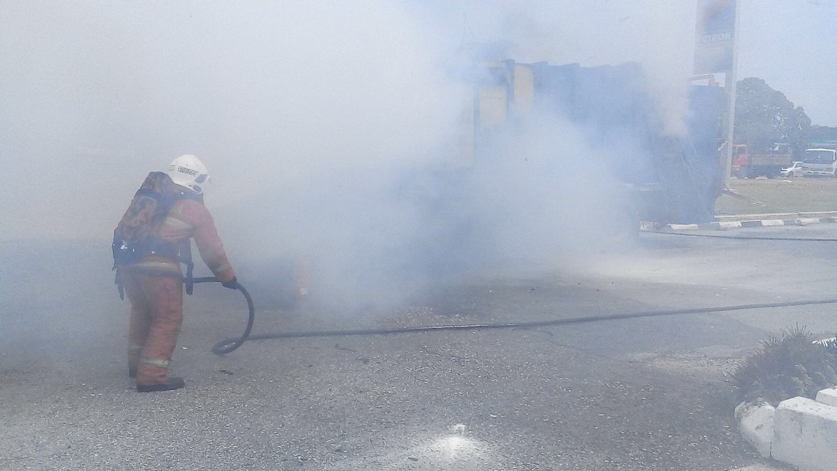 Firemen putting out the flames after a garbage truck caught fire at a Petron petrol station. – Pic courtesy of the Fire and Rescue Department, March 11, 2016.