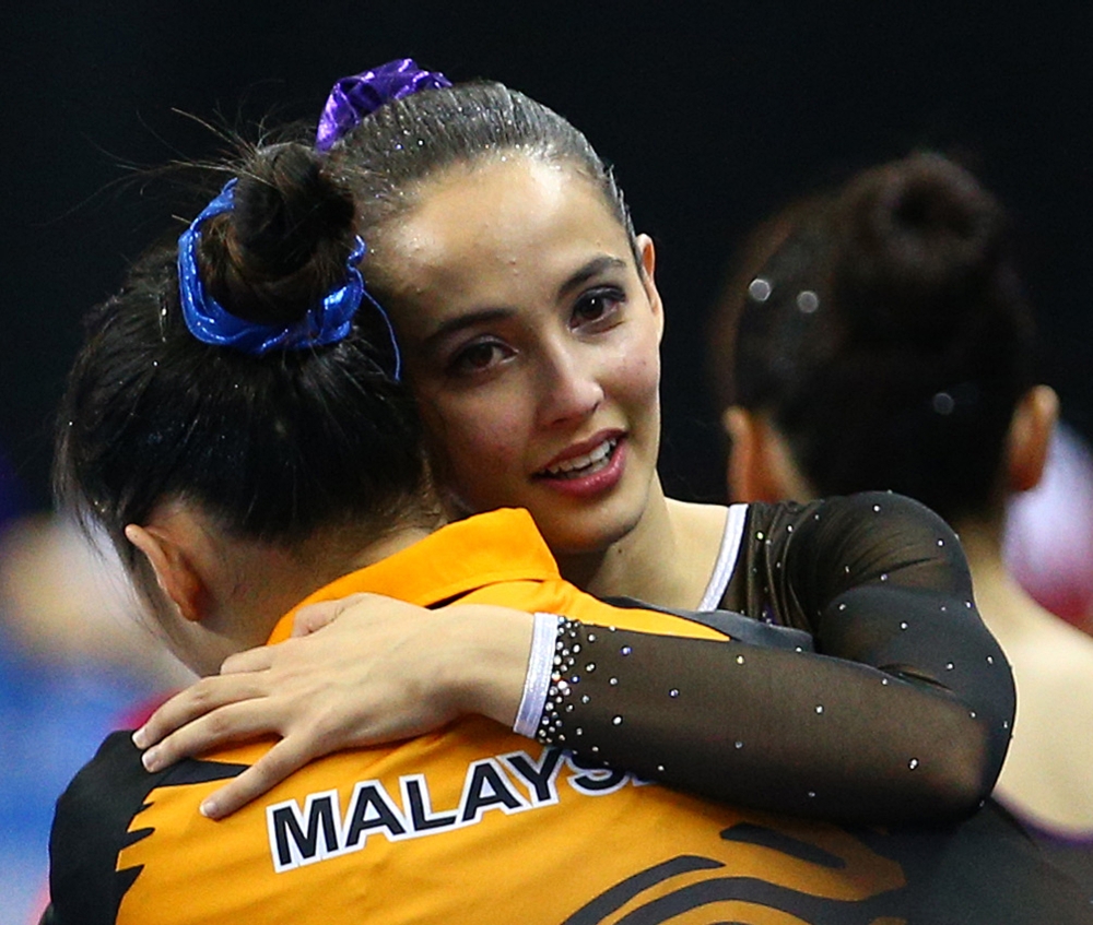 Malaysian gymnast Farah Ann Abdul Hadi congratulated by her teammate after winning the gold at the SEA Games on June 10. Farah today hit back at her critics over her 'revealing' attire at the games. – Reuters pic, June 13, 2015.