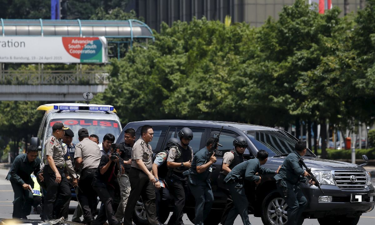 Indonesian police use a car as cover as they walk slowly towards the scene of a bomb blast near the Sarinah Mall in Jakarta today. – Reuters pic, January 14, 2016.