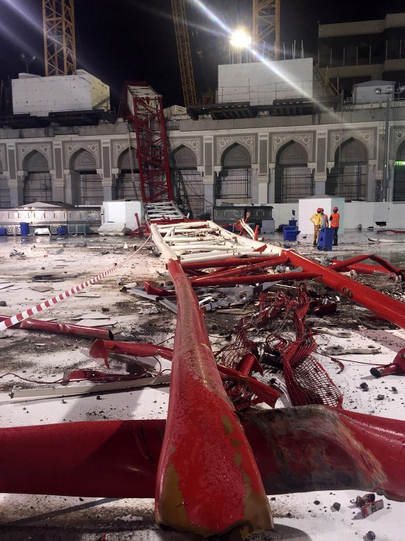 Saudi emergency teams stand next to a construction crane after it crashed into the Grand Mosque in Mecca yesterday. At least a 107 people were killed and scores injured. – AFP pic, September 12, 2015. 