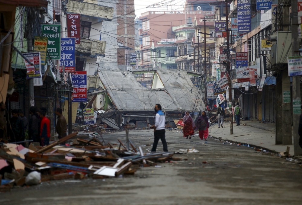 People walk along a deserted road near a collapsed house after the earthquake in Kathmandu, Nepal. – Reuters pic, April 29, 2015.