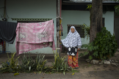 Housewife Siti Minah Mahmud standing beside a pole that saved her live during the tsunami in Kuala Muda, Kedah. She hung on to the pole when the second wave of the tsunami hit. – The Malaysia Insider pic by Hasnoor Hussain, December 26, 2014.